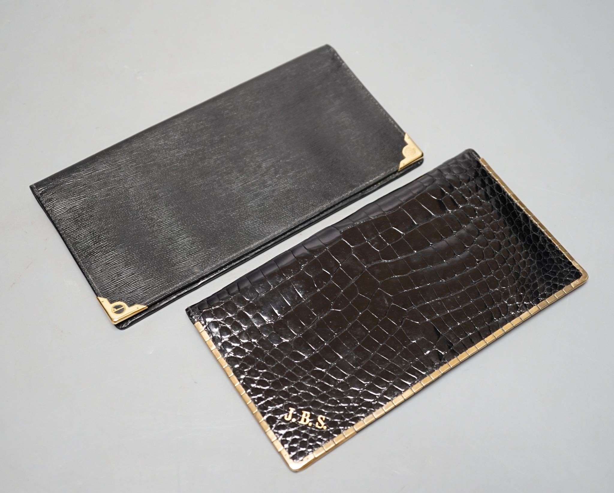 An Alfred Dunhill gold plate mounted leather wallet, 18.9cm, and one other 9ct gold mounted leather wallet initialled J.B.S., 17.9cm.